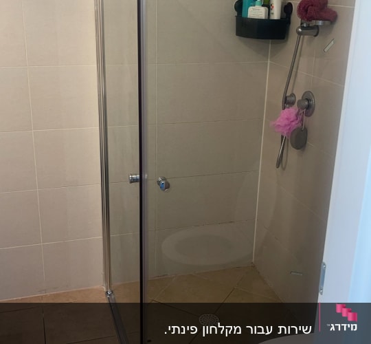 מקלחון זכוכית עם ראש מקלחת ומדף מוצרים
